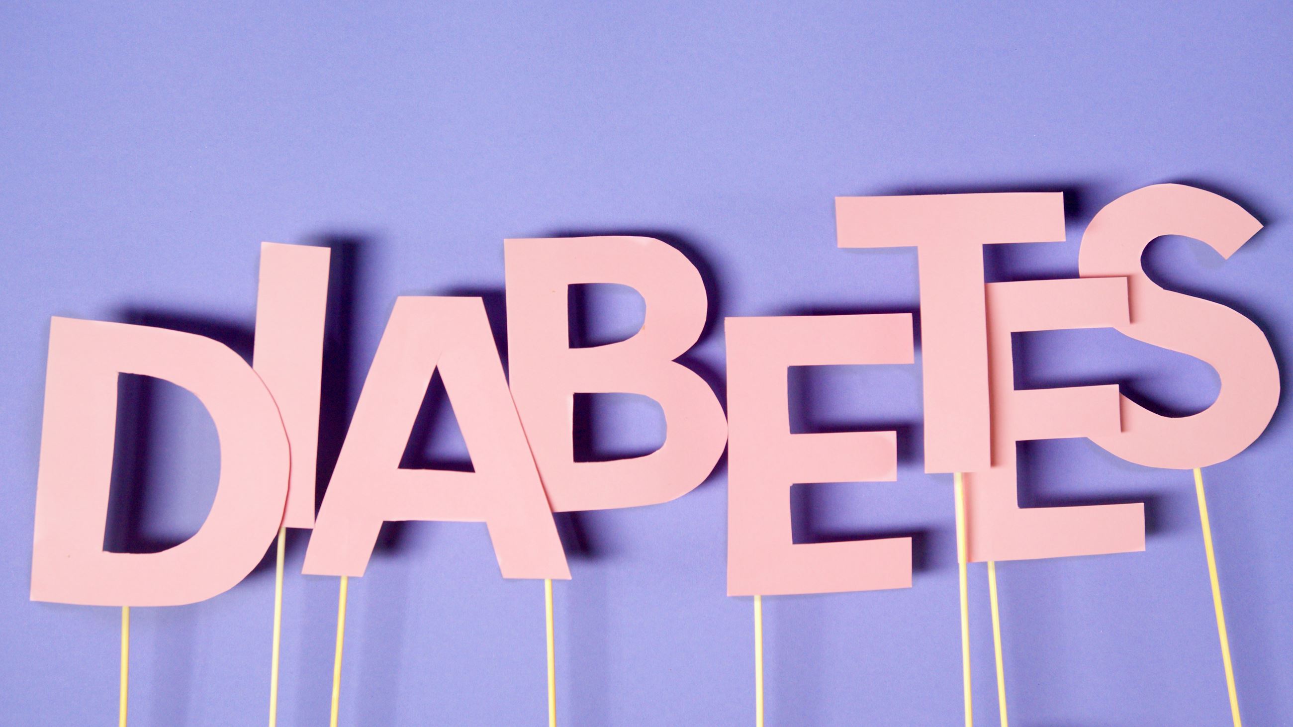 Pink letters on thin wooden sticks that spell DIABETES. Purple background. Pexels.com image