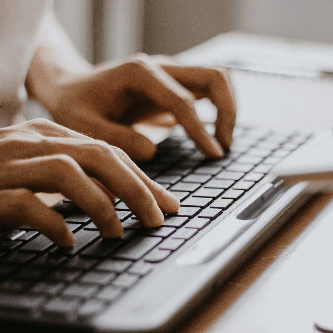 hands poised to type on a computer keyboard