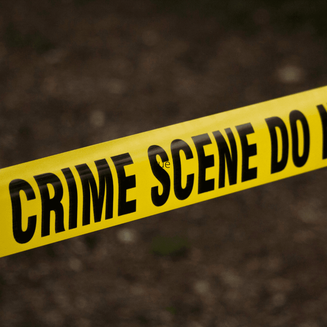 Crime tape over a blurred brown outdoor appearing background