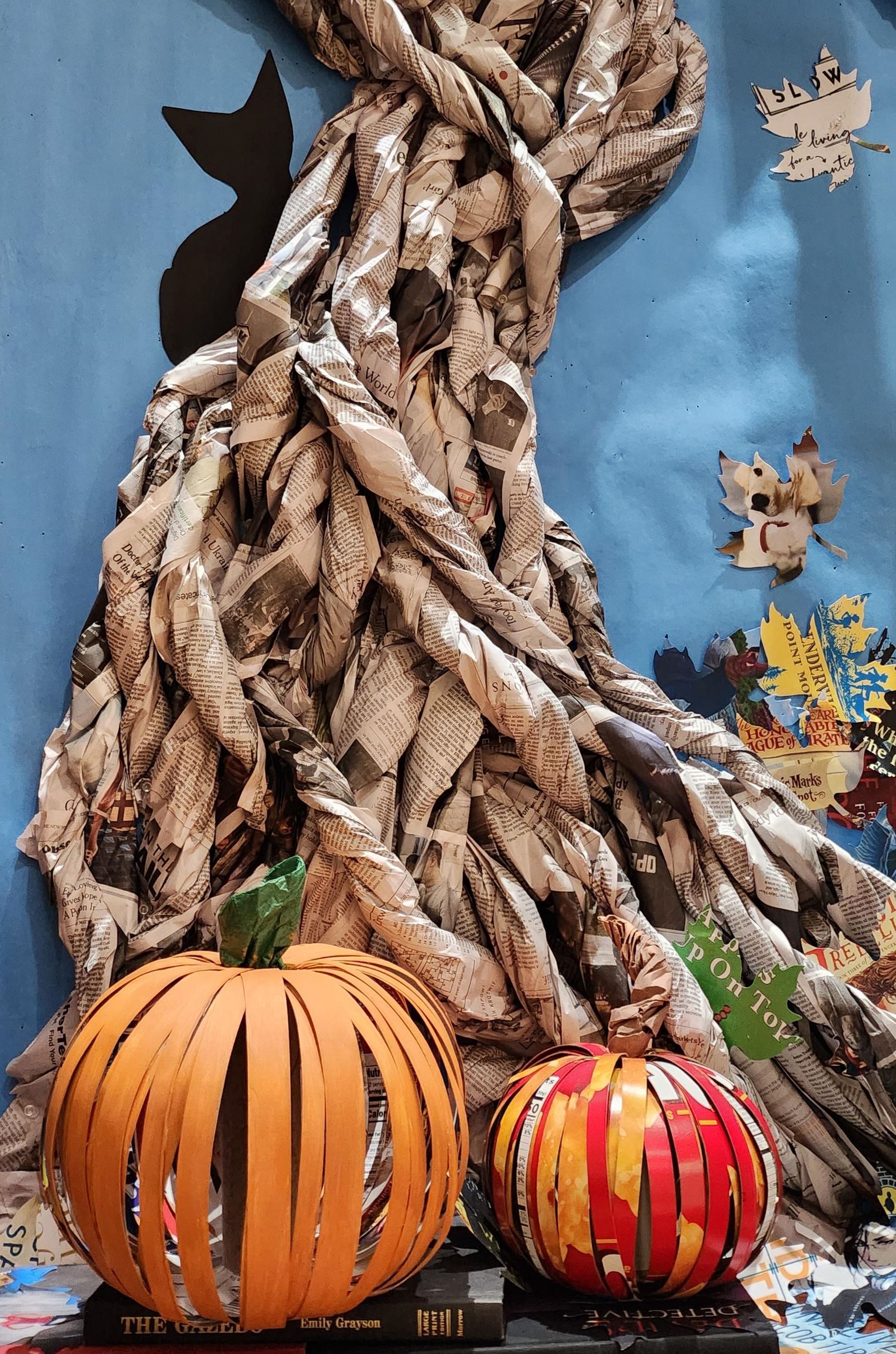 Orange pumpkins and haunted tree made from recycled materials with seasonal elements.