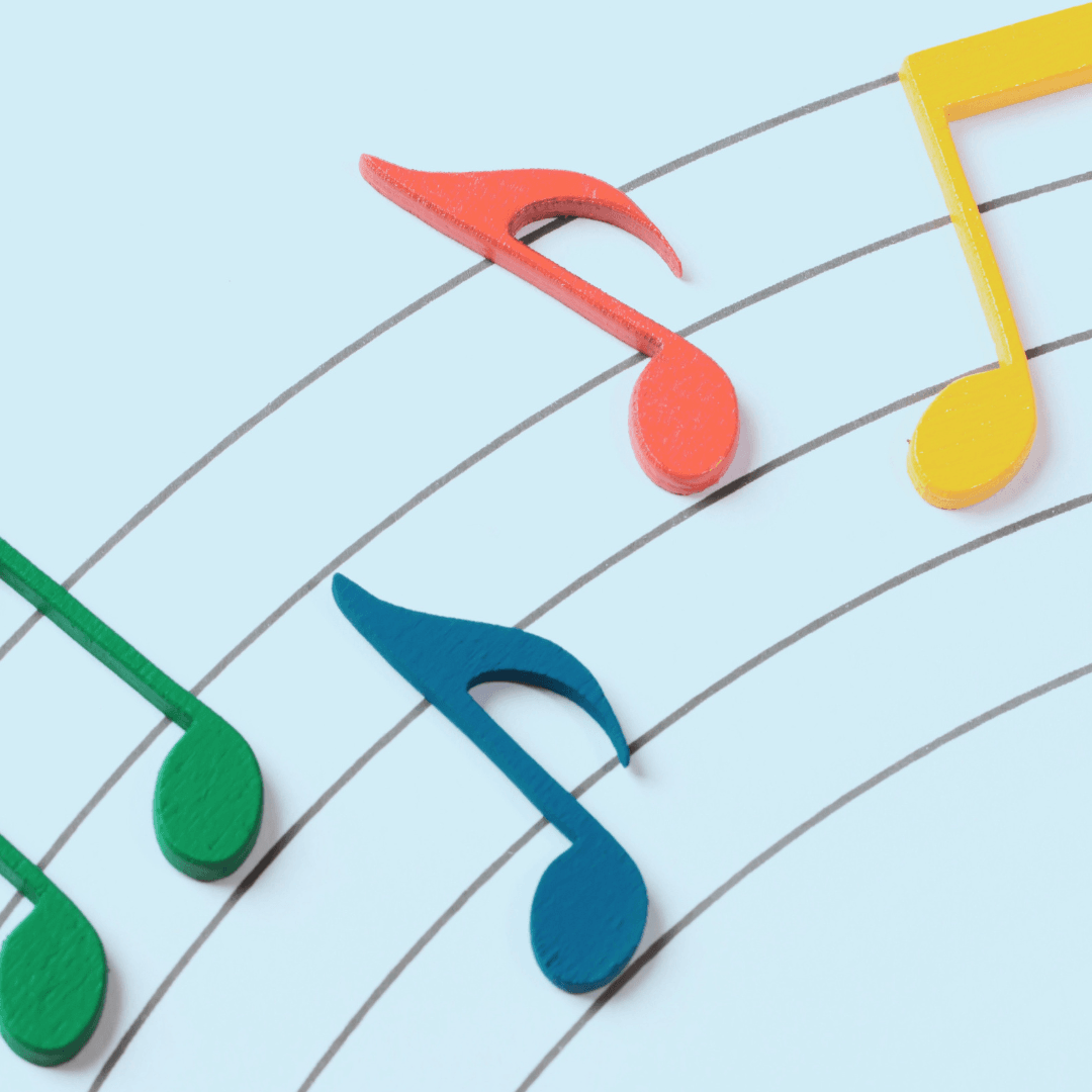 4 Large music notes in primary colors on lines like sheet music