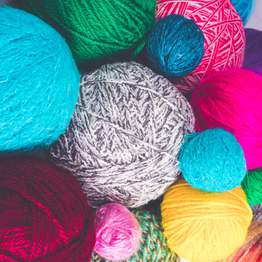 Photo of multiple balls of yarn in a variety of colors