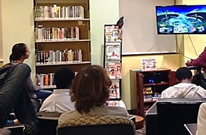 Teens hanging out in the teen room playing video games