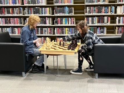 teen room chess table with two teens sitting and playing chess