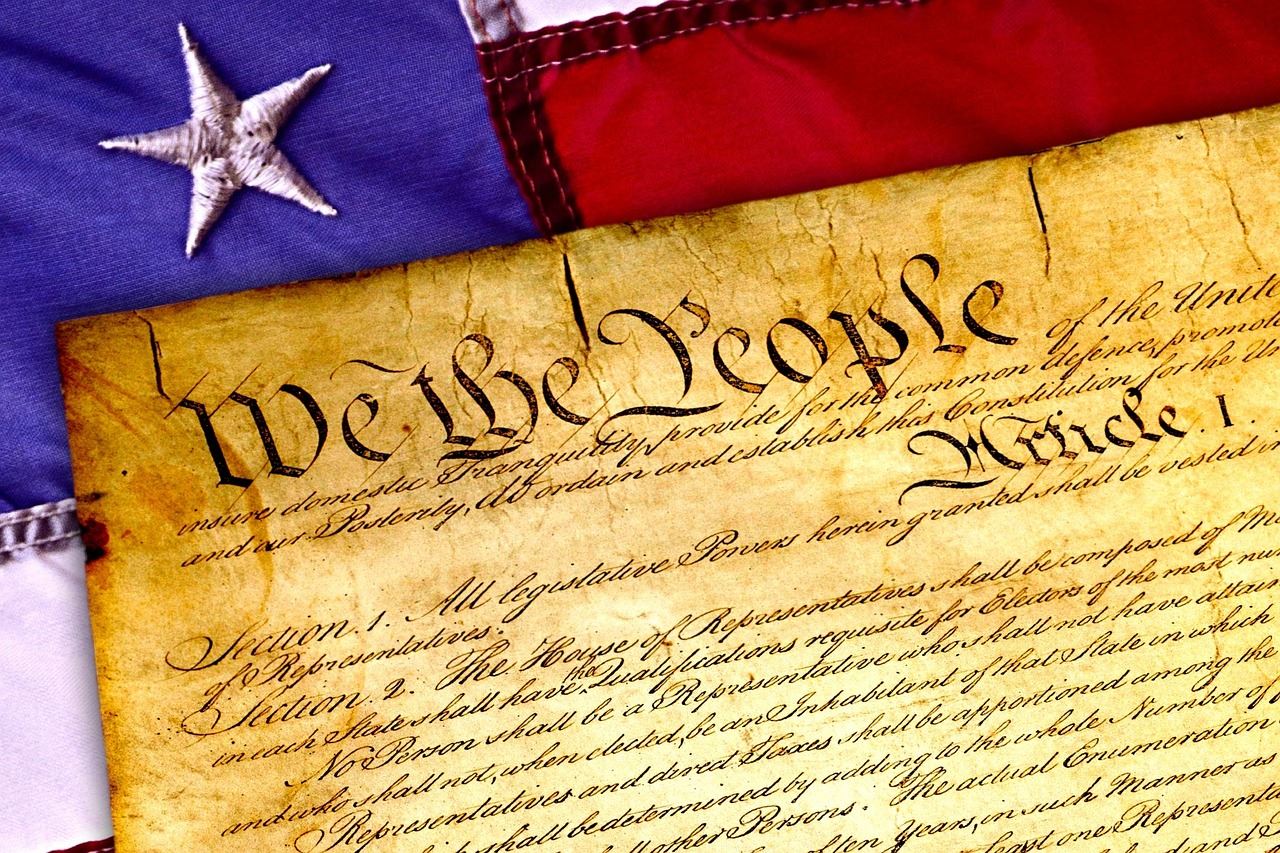 Image of part of the American flag with the Constitution laying on top of the flag,